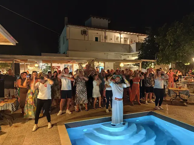 Greek Night: guests dancing round the pool, led from the pool steps